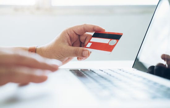 Hand with credit card and laptop